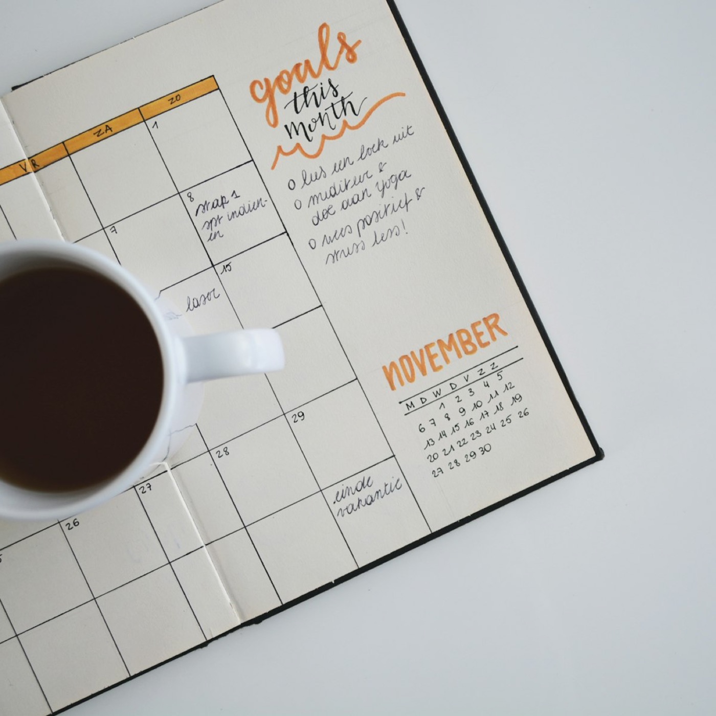 Open planner and coffee mug on a desk, for picking drop-off dates