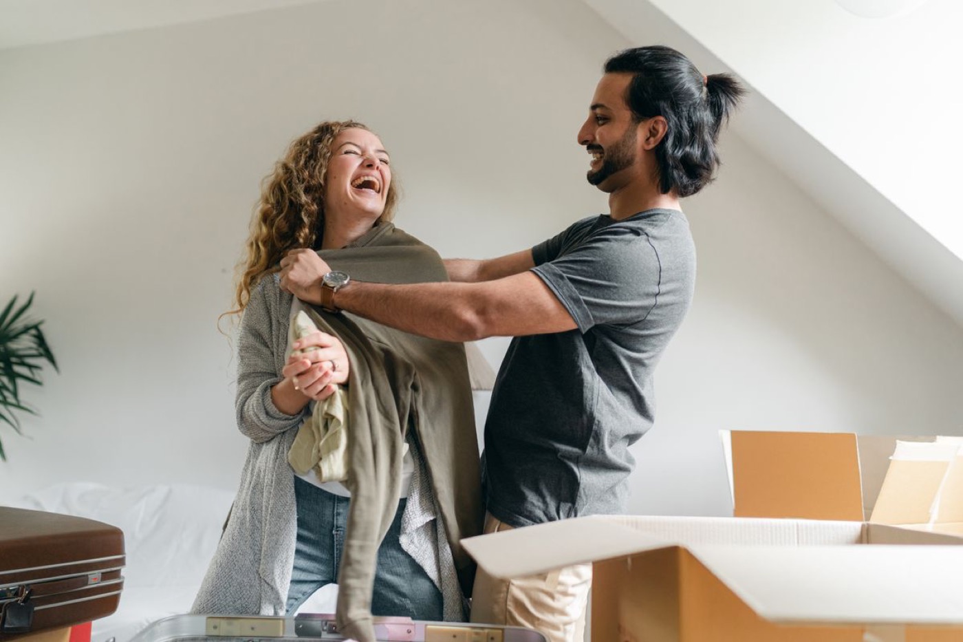 A couple unpacking clothes in a bright room after the move